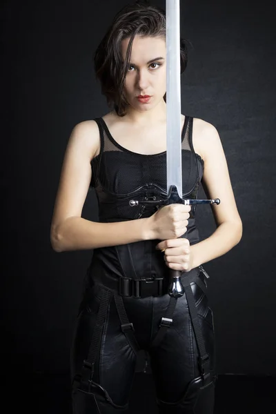 Woman in urban-fantasy style costume posing with a variety of weapons