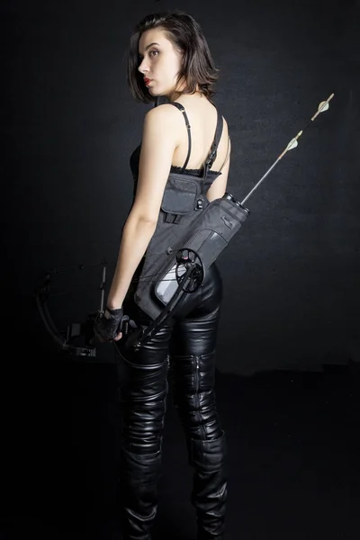 Woman in urban-fantasy style costume posing with a variety of weapons