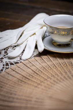 Bir tuvalet masasında eldiven, inci ve diğer öğeleri ile Vintage fan