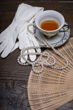 Bir tuvalet masasında eldiven, inci ve diğer öğeleri ile Vintage fan