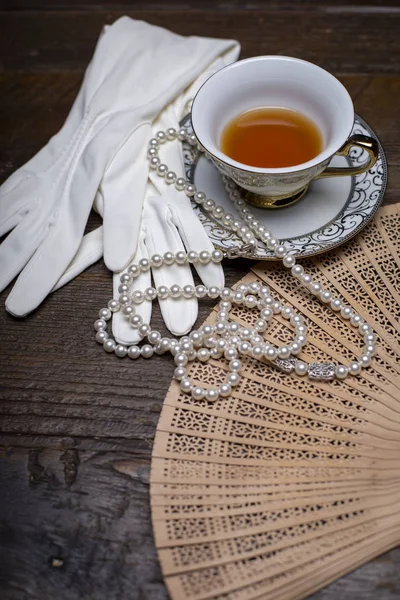 Bir tuvalet masasında eldiven, inci ve diğer öğeleri ile Vintage fan