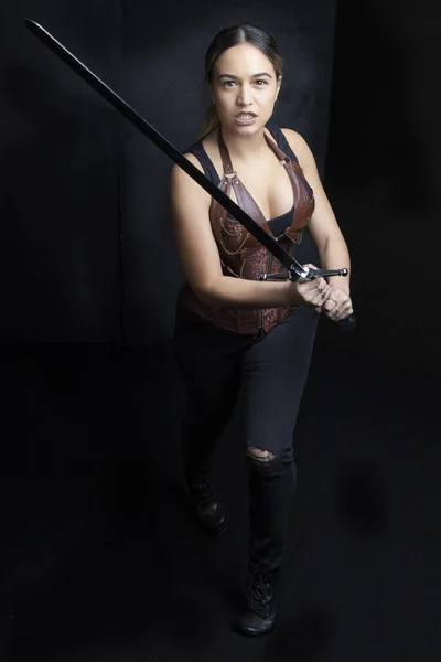 Young woman in urban fantasy poses on a black background