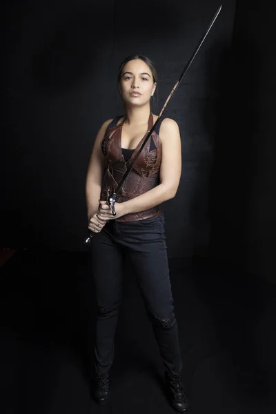 Young woman in urban fantasy poses on a black background