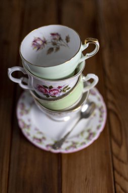 Ahşap bir masaya yığılmış vintage çay fincanları