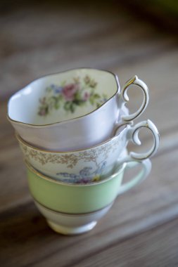 Ahşap bir masaya yığılmış vintage çay fincanları
