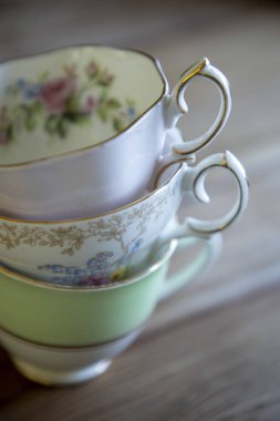 Ahşap bir masaya yığılmış vintage çay fincanları