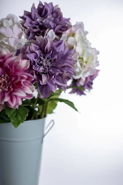 Silk flowers in a tall metal vase