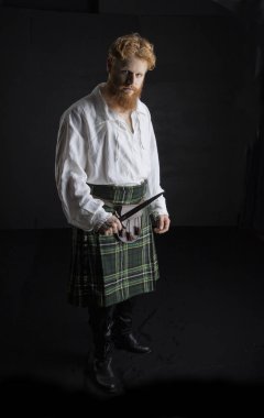 Kızıl saçlı ve sakallı genç bir İskoç.