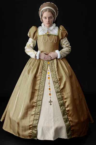 Uma Mulher Tudor Usando Vestido Ouro Contra Pano Fundo Preto — Fotografia de Stock