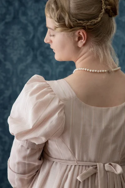 ピンクのガウンと真珠のネックレスを着た若いリージェンシーの女性 — ストック写真