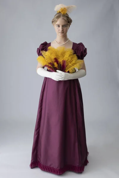 Kobieta Regencji Śliwkowej Sukni Wieczorowej Piórami Włosach — Zdjęcie stockowe