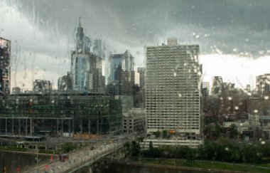 Bir şehir yağmur aracılığıyla bakarak bir binanın cam çizgili.