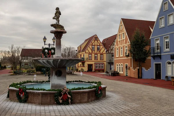 A water fountain on a plaza in a small European style village.