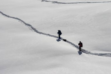İnsanlar karda doğa yürüyüşü