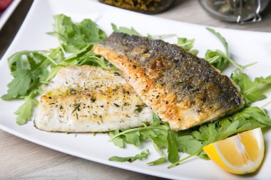 Roka ve limon ile ızgara levrek fileto. Yakın çekim.