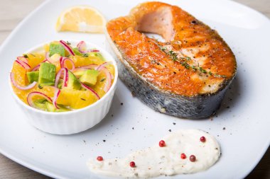 Izgara somon, portakal ve avokado salatası. Yakın çekim, seçici odak.