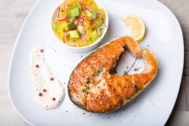 Izgara somon, portakal ve avokado salatası. Yakın çekim, seçici odak.