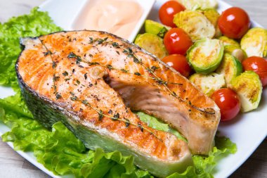 Brüksel lahanası ve domates ile ızgara somon. Yakın çekim, seçici odak.