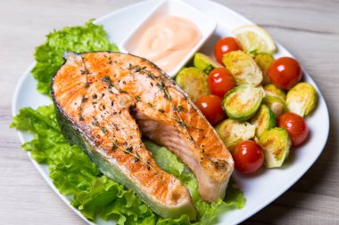 Brüksel lahanası ve domates ile ızgara somon. Yakın çekim, seçici odak.