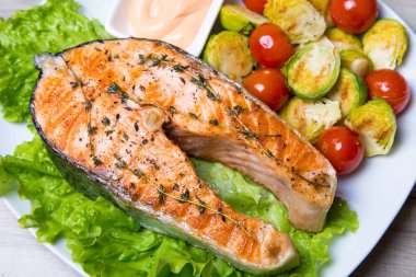 Brüksel lahanası ve domates ile ızgara somon. Yakın çekim, seçici odak.