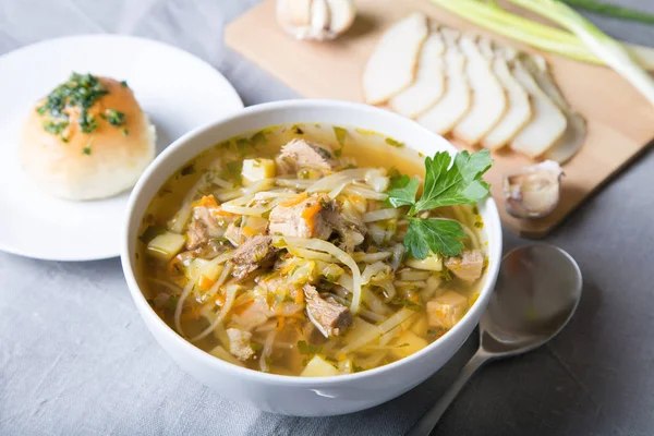 Shchi (cabbage soup) with buns (pampushki), fat and garlic. Traditional Russian and Ukrainian soup. Selective focus, close-up.