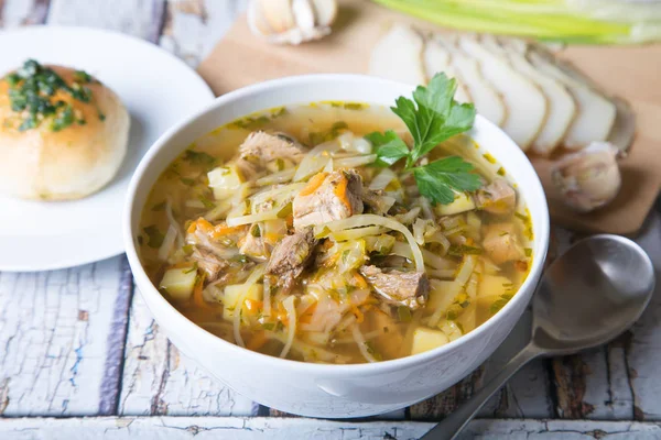 Shchi (cabbage soup) with buns (pampushki), fat and garlic. Traditional Russian and Ukrainian soup. Selective focus, close-up.