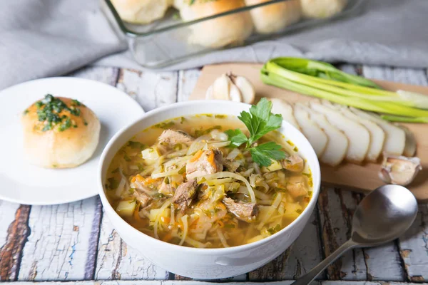 Shchi (cabbage soup) with buns (pampushki), fat and garlic. Traditional Russian and Ukrainian soup. Selective focus, close-up.