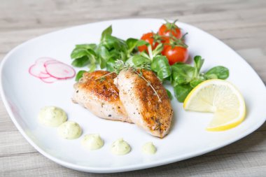 Fried bıldırcınlar, salata yaprakları Mısır, kiraz, turp ve limon. Seçici odak, yakın çekim.