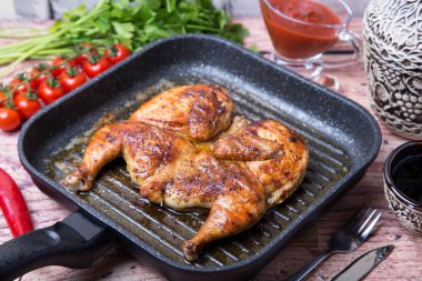 Kızarmış tavuk tütün (tabaka) bir ızgara tava. Seçici odak, yakın çekim.