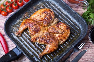 Kızarmış tavuk tütün (tabaka) bir ızgara tava. Seçici odak, yakın çekim.