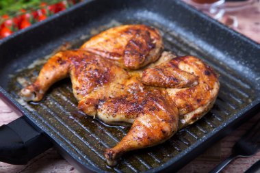 Kızarmış tavuk tütün (tabaka) bir ızgara tava. Seçici odak, yakın çekim.