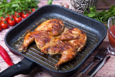 Kızarmış tavuk tütün (tabaka) bir ızgara tava. Seçici odak, yakın çekim.