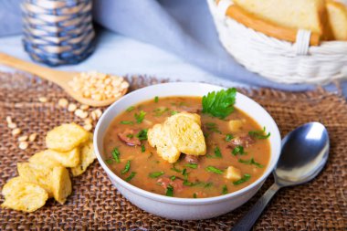 Et, füme sosis ve croutons ile bezelye çorbası. Seçici odak, yakın çekim.