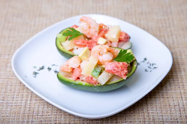 Salad with shrimps, avocado, pineapple and grapefruit in half avocado. Selective focus, close-up.