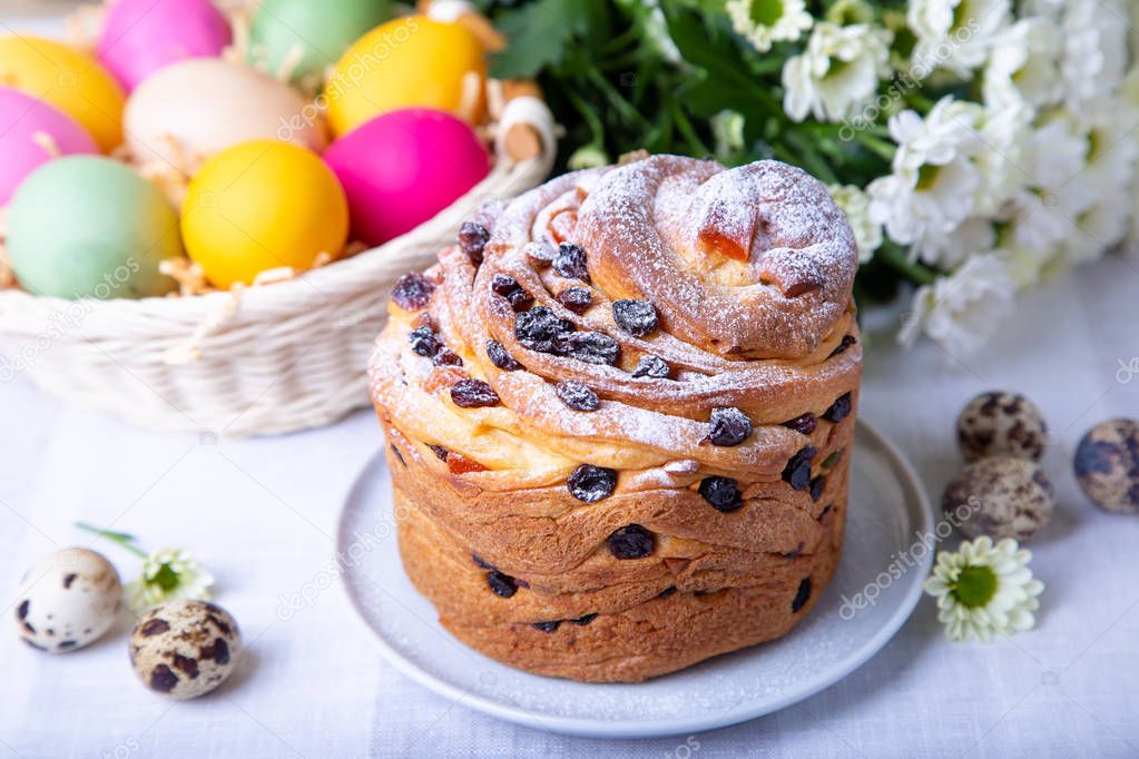 Craffin (Cruffin) with raisins and candied fruits. Easter Bread Kulich and painted eggs. Easter Holiday. Close-up.