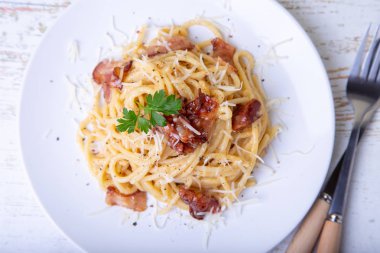 Pastırma, peynir Parmesan ve maydanoz ile Makarna carbonara. Geleneksel İtalyan yemeği. Yakın çekim, seçici odak.