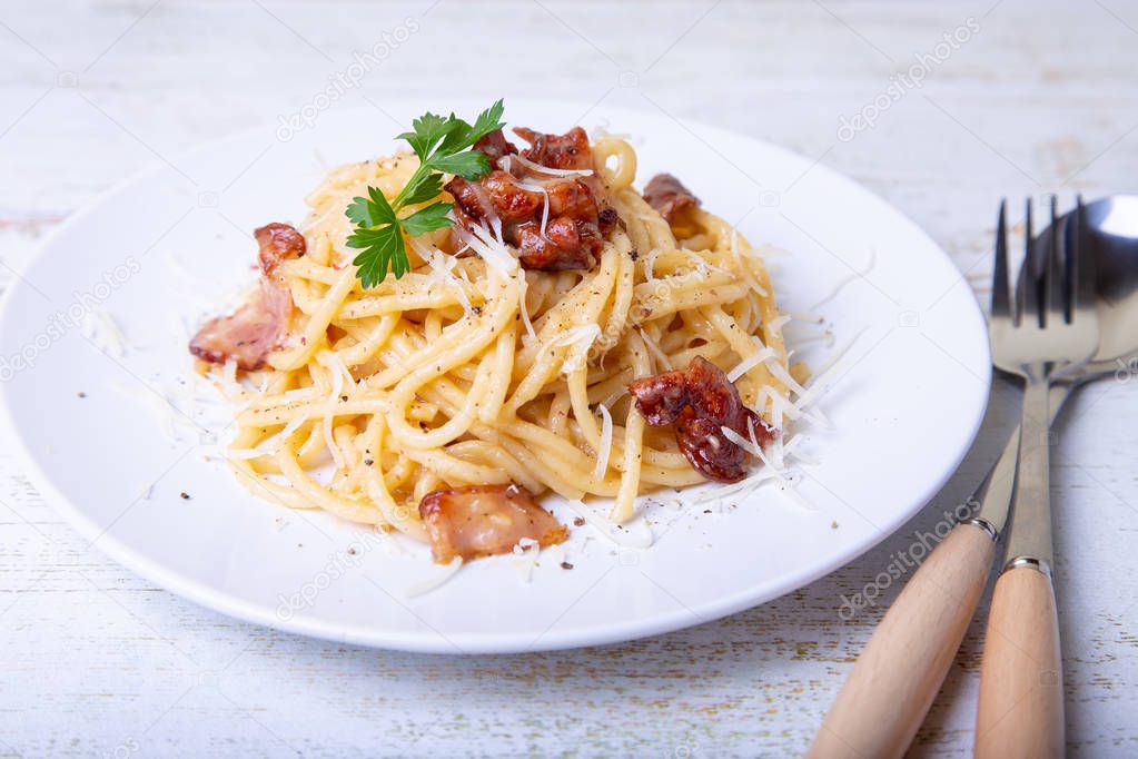 Pasta carbonara with bacon, cheese Parmesan and parsley. Traditional Italian dish. Close-up, selective focus.