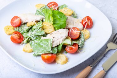 Tavuk, kraker, parmesan ve kiraz domates ile Sezar (cesar) salatası. Close.