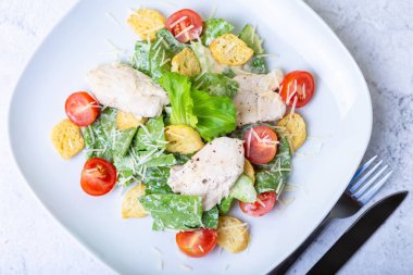 Tavuk, kraker, parmesan ve kiraz domates ile Sezar (cesar) salatası. Close.