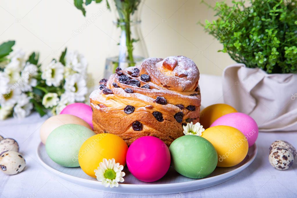 Craffin (Cruffin) with raisins and candied fruits. Easter Bread Kulich and painted eggs. Easter Holiday. Close-up.