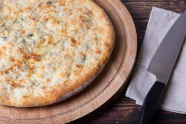 Peynirli ve otlu Osetya turtası (dereotu, maydanoz, soğan). Geleneksel Osetya pişirmesi.