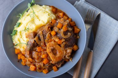 Ossobuco. Dana inciği, patates püresi, gremolata ve sos. Geleneksel İtalyan yemeği. Yakın plan..