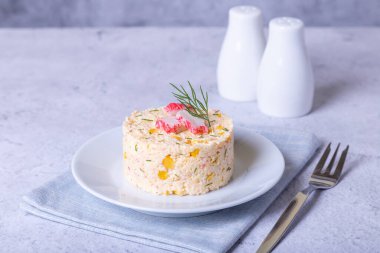 Beyaz tabakta mısır ve yumurta ile yengeç salatası. Porsiyonlar halinde hizmet veriyor. Geleneksel Rus salatası. Yakın plan..