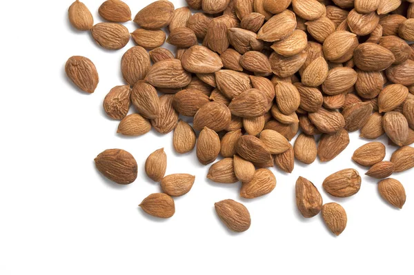 Beyaz arka plan üzerinde izole kayısı çekirdekleri yığını.