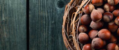 Tahta bir arka planda sepetin içinde fındıklar. Panorama. 