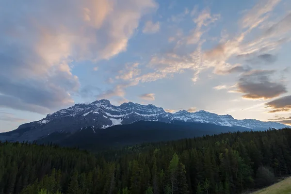 Deels bewolkte zonsondergang boven bergen en bos — Stockfoto