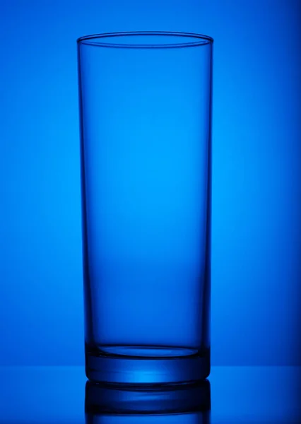Copo de vidro transparente, no fundo azul. arte, assunto, publicidade . — Fotografia de Stock
