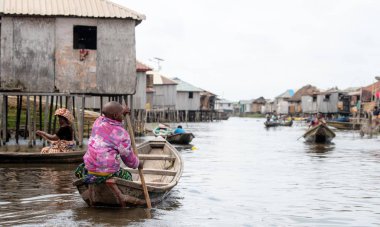 Kadın teknede gıda ile piyasada olacak. Benin lake Nokou yaşam tarzı Afrika köylü su evde yaşayan. Ticaret takas sistemi. Benin renkli geleneksel moda hayatta Batı Afrika.