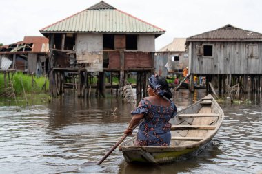Kadın teknede gıda ile piyasada olacak. Benin lake Nokou yaşam tarzı Afrika köylü su evde yaşayan. Ticaret takas sistemi. Benin renkli geleneksel moda hayatta Batı Afrika.