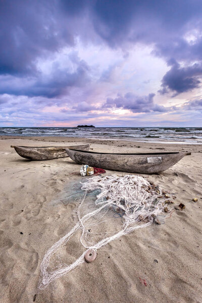 Lake Malawi sunset in Kande beach Africa, canoe boat on beach peaceful beach holiday beautiful sunset colors blue purple orange yellow in sky and clouds